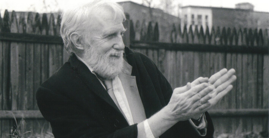 A black and white image of Ran Blake gesturing a book hand movement